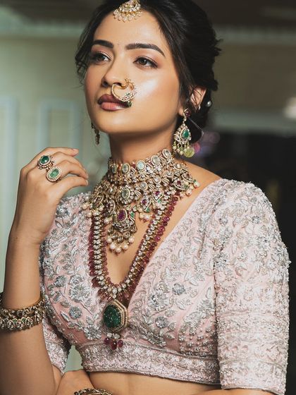 Twirl into a fairytale with this baby pink bridal lehenga. I designed it with intricate horse embroidery on the raw silk skirt and paired it with a heavily handworked blouse and a delicate net dupatta for a truly heavenly look.
