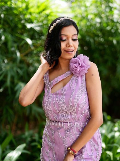 A soft and elegant party look. The makeup features a subtle smokey eye and nude lips, complementing her lavender gown perfectly.