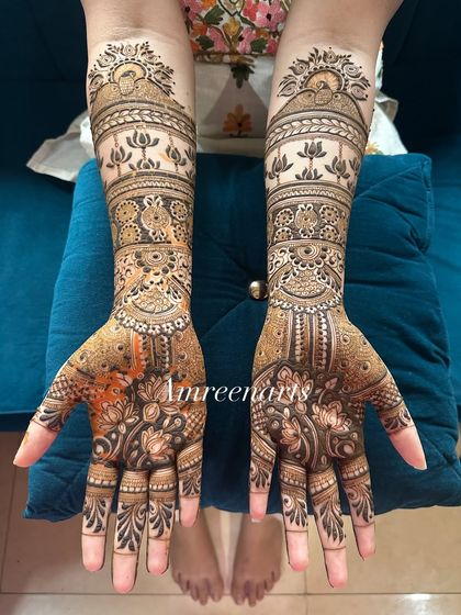 A beautifully balanced design with intricate lotus and geometric bands extending up the forearm.