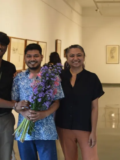 The artist Mohit Mahato, holding a bouquet of flowers, poses with friends at the successful preview of his show.