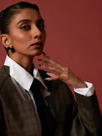 A side profile showing off the custom nails for Dolly Singh. The design perfectly complements her sharp, tailored look.