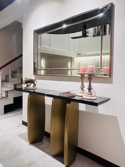 This image shows the complete console and mirror set in its foyer setting. The sculptural PVD gold base of the table creates an elegant and welcoming entryway statement.