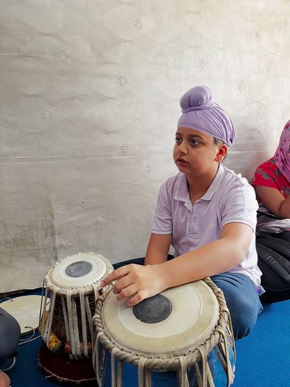 A student in deep concentration during a tabla class, focusing on the foundational elements of taal.