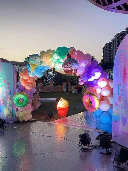 The Candyland entrance archway, beautifully lit up as the sun sets, creating a magical and inviting atmosphere for the guests.