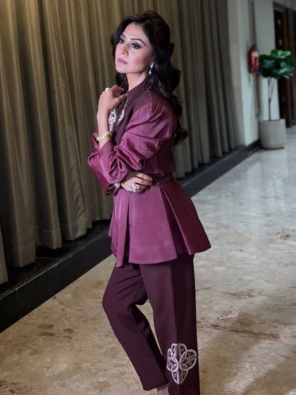 A full shot of the client in her stylish pantsuit. The soft, voluminous hairstyle adds a touch of femininity to the powerful and modern outfit.