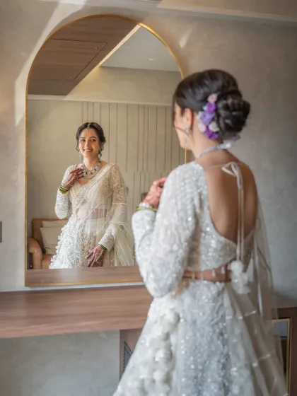 A beautiful getting-ready shot of the bride admiring her reflection. These quiet, happy moments before the ceremony are so special to capture.