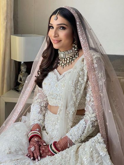 The soft waves and pink-toned dupatta create a dreamy and ethereal bridal look.
