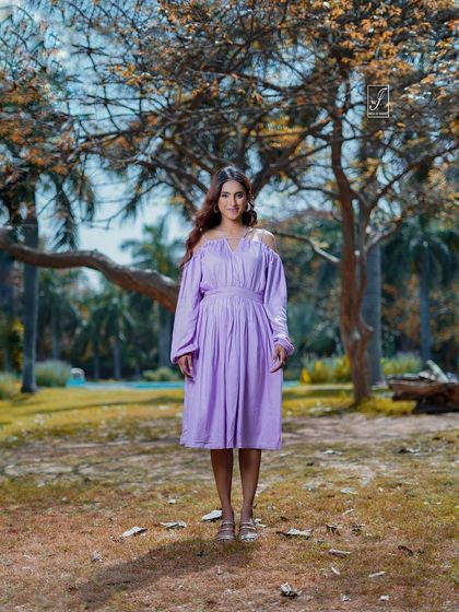 A classic standing portrait that showcases the full dress against a beautiful natural backdrop of trees and soft light.