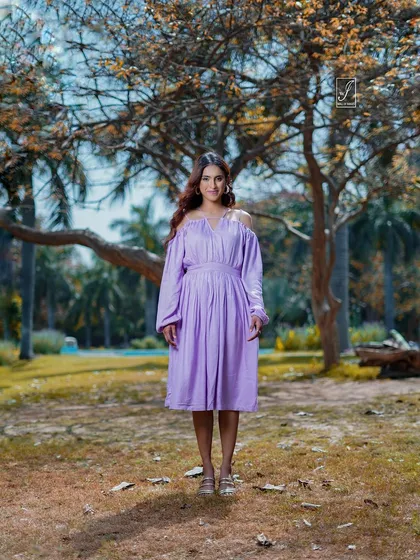 A classic standing portrait that showcases the full dress against a beautiful natural backdrop of trees and soft light.