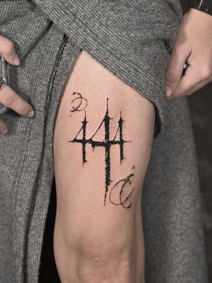 An abstract, fine-line symbol on the thigh. This kind of minimalist design is perfect for clients who want something personal and unique without being overly descriptive.