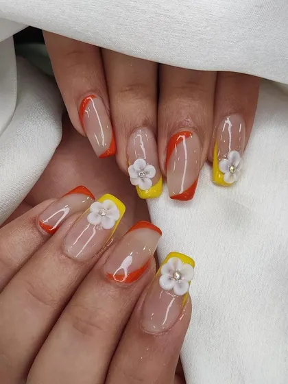 Another angle of the cheerful yellow and orange French manicure with 3D flower accents.