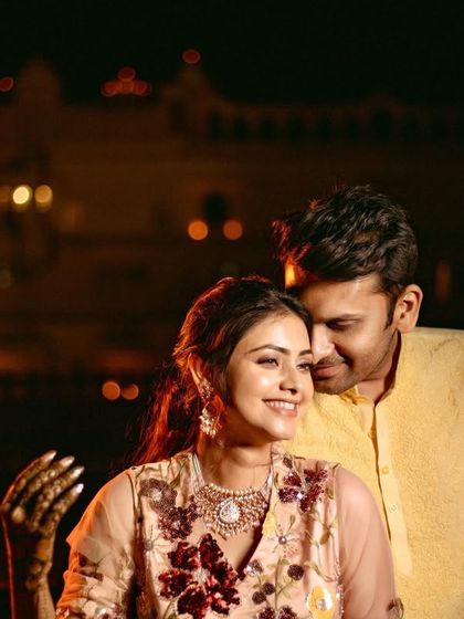 A romantic night portrait of the couple with the beautifully lit palace in the background.