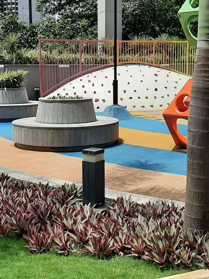 Our playground designs incorporate custom-designed seating and planters that match the playful aesthetic. The circular concrete bench and planters provide a comfortable spot for parents to supervise while being an integrated part of the landscape.