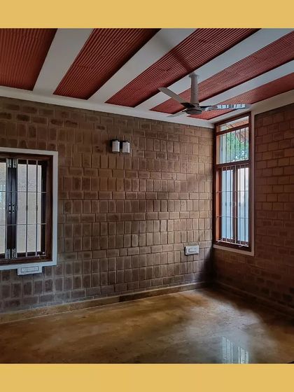 A bedroom with exposed soil cement block walls and a jack arch ceiling, creating a rustic and earthy ambiance.