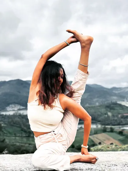 A moment of deep focus and flexibility in this standing compass pose, set against a beautiful mountain landscape. This asana requires open hips and hamstrings.