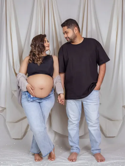 A casual and modern couple's portrait. The simple act of holding hands shows their connection as they wait for their little one.