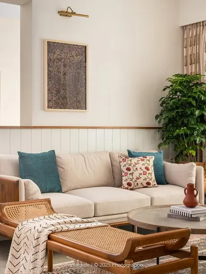 We love to blend textures to create warm, inviting living spaces. In the 'Palaash' project, we used a mix of wood, rattan, and soft fabrics to craft a contemporary yet earthy feel. The curved half-wall and custom TV unit with dual-side access add a layer of bespoke functionality and visual softness to the room.