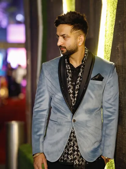 A close-up of the light blue velvet blazer, highlighting its soft texture and the elegant black shawl lapel.