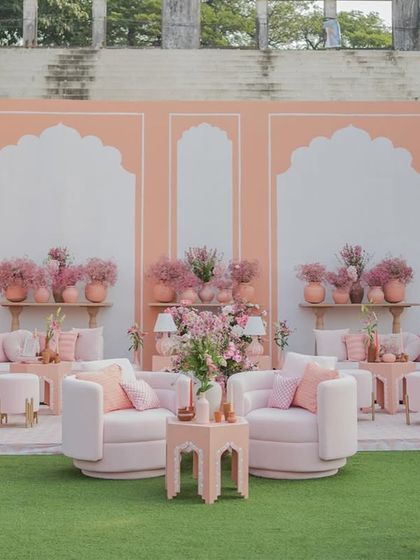 Our 'Handpainted Story' wedding theme, featuring a backdrop of large-scale, hand-painted arches in soft pink hues for a romantic and artistic statement.