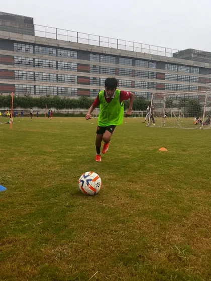 A player dribbling at speed during a training drill, showing focus and determination.