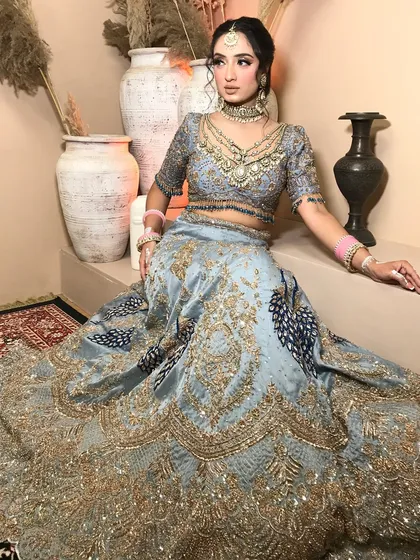 A full-length view of the bride in her stunning powder blue lehenga, showcasing the entire styled look from the maang tikka to the hem.