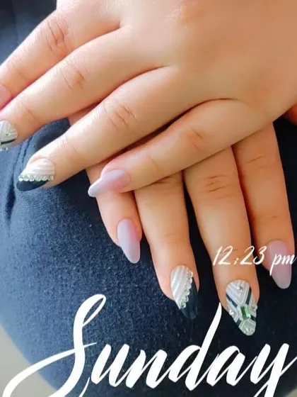 I really enjoy playing with textures and patterns, like in this design. It features a mix of matte nude, black, and a textured silver-and-white pattern on long, almond-shaped nail extensions.