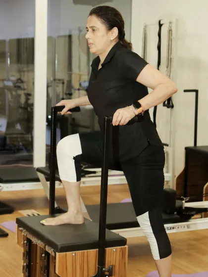 A close-up shot of a client using the Pilates chair, focusing on control and precision in her movements.