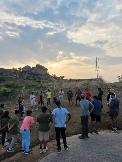 A morning briefing session with the group at the summit, with the beautiful sunrise sky in the background.