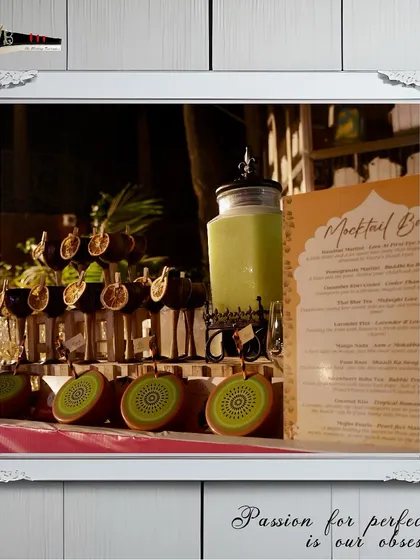 A beautifully arranged mocktail bar with a menu featuring Lavender Fizz, Paan Raas, and Strawberry Boba Tea.