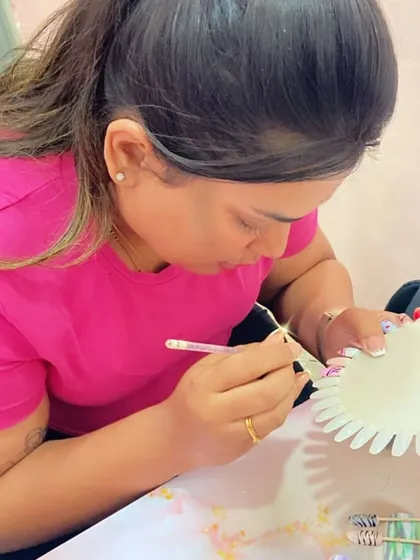 A student works on her nail art, showing the focus and creativity that goes into every design.