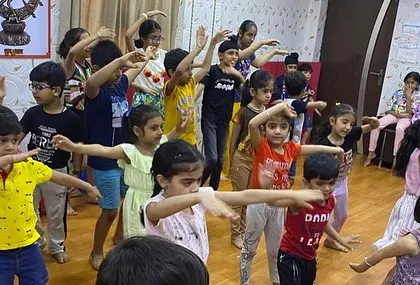 Children practice a synchronized dance move, showcasing their ability to learn and work together as a team during a fun and active session.