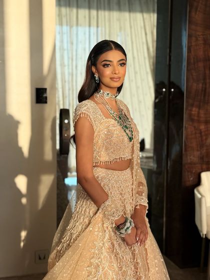 A poised and elegant portrait. The bride's makeup is flawless, and her emerald and diamond jewelry adds a touch of royalty.
