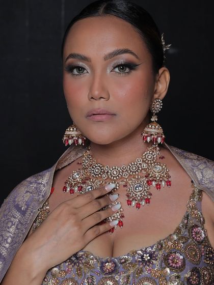 The model showcases the full set, including the large, statement jhumkas.