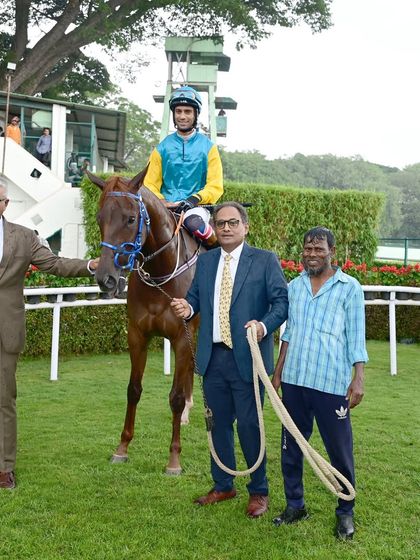 Scent of Rain, with jockey P. Trevor, is pictured with the winning team after its victory in the memorial cup race.