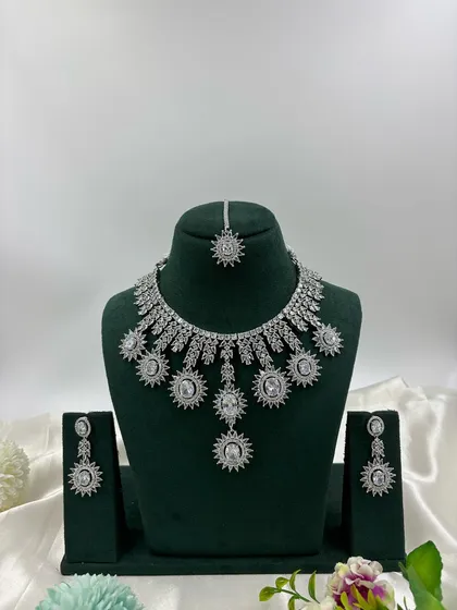 Get that brilliant diamond look for your cocktail party or reception. This silver-finish necklace set is crafted with high-quality stones that catch the light beautifully, giving you a glamorous and modern style. It’s perfect for western gowns and contemporary lehengas.