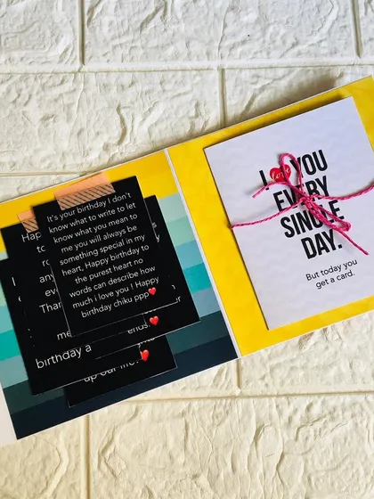 An inside page of a birthday flipbook, with space for personal messages and a small, tied-up card for a secret note.