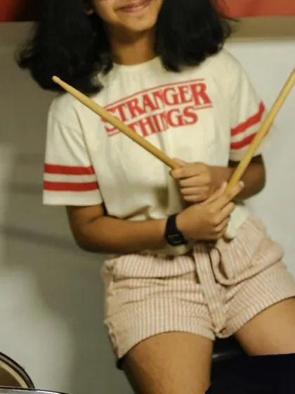 A student ready for her drum lesson, wearing a Stranger Things t-shirt. We love when our students' passions intersect with their music.