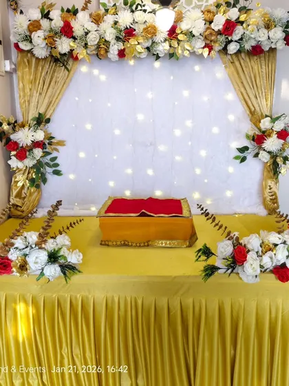 This classic decoration combines rich golden drapes with bouquets of red, white, and gold artificial flowers. The backdrop of white fabric with warm fairy lights provides a bright and celebratory space for your Ganpati mandap.