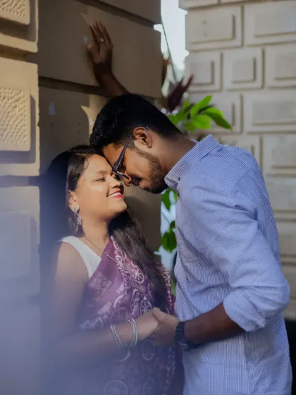 A tender moment between the couple, framed in a doorway. The groom's gentle forehead kiss is a classic expression of love.