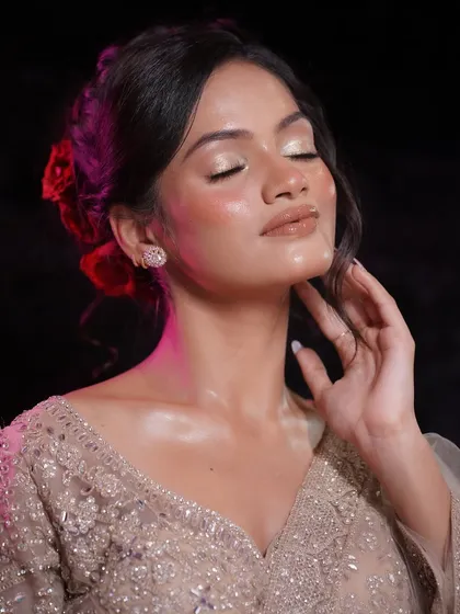 Eyes closed to show the soft, shimmery eyeshadow that complements the glowing skin. The entire look is cohesive and harmonious.
