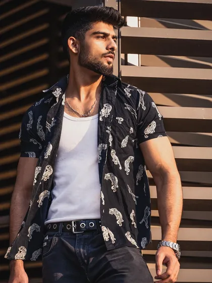 A three-quarter shot of the model in a printed shirt and jeans, showcasing a complete casual look with a focus on style and attitude.