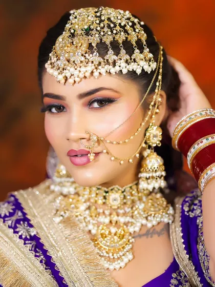 A stunning close-up of the bridal makeup and jewelry. Notice the perfectly sculpted brows, the blended eyeshadow, and the way the matha patti frames the face.