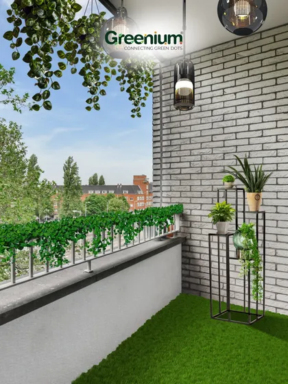 The final result of our balcony makeover. The combination of a green lawn, hanging vines, and a tiered plant stand adds layers of greenery, making the space feel lush and full without being cluttered.