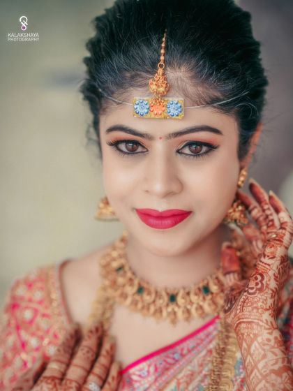 A striking close-up portrait of a bride, highlighting her beautiful makeup and traditional jewelry.