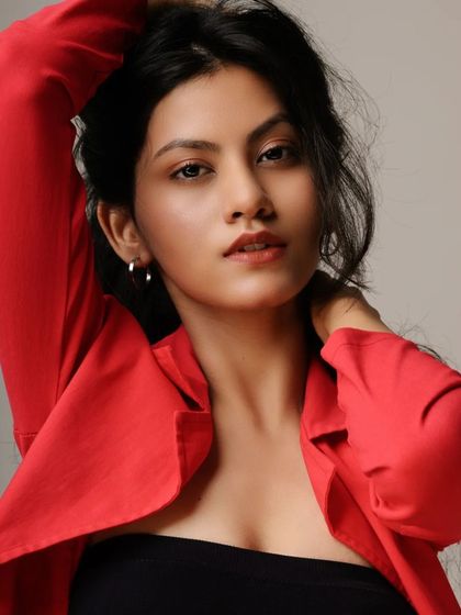 A bold and energetic studio shot. The combination of the red blazer, white jeans, and dynamic pose creates a high-impact image that is perfect for a fashion-forward portfolio.