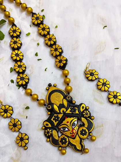 This is another one of my Durga-themed creations, perfect for the festive season. The large, ornate pendant features a sculpted Durga face, complemented by a chain of floral beads in black and gold.