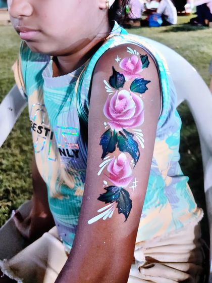 A beautiful temporary tattoo of pink roses climbing up the arm.
