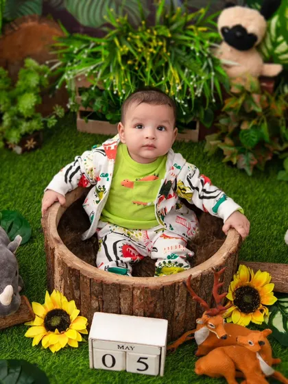 A little explorer in the jungle. The log tub and surrounding stuffed animals create a safe and fun safari environment.