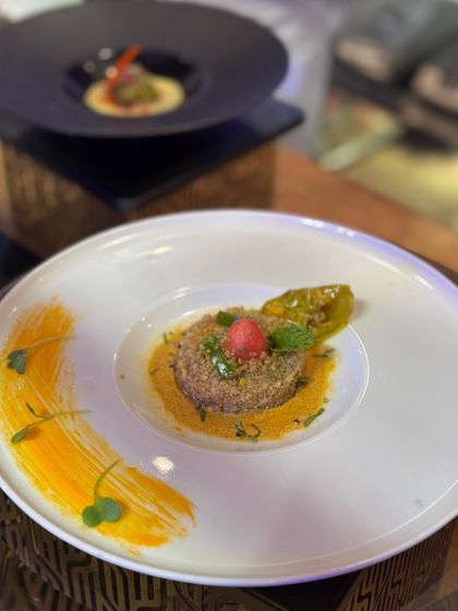 A beautiful quinoa salad with a bright yellow sauce brushed onto the plate, demonstrating our belief that the plate itself is part of the art.