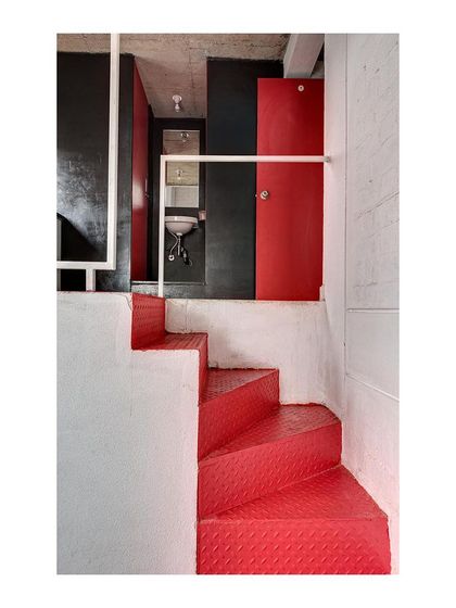 The folded red steel plate staircase is a central feature in each student housing unit. It provides access to the loft and bathroom while also serving as a vibrant, sculptural element that injects color and character into the space.